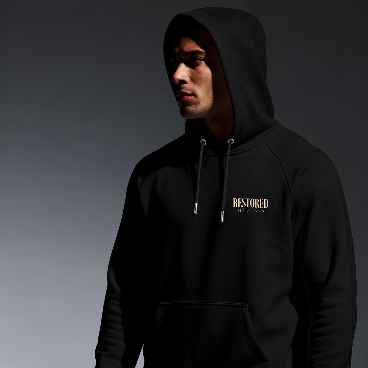 Man wearing the black Healed to Heal hoodie with RESTORED Isaiah 53:5 chest print