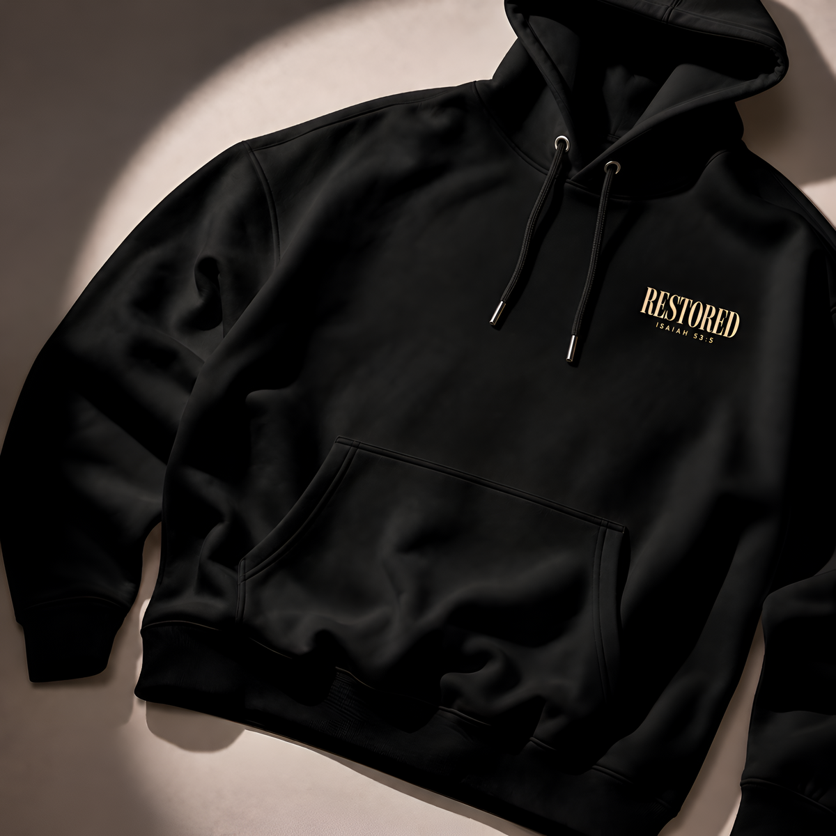 Black heavyweight Christian hoodie with RESTORED chest print, flat lay